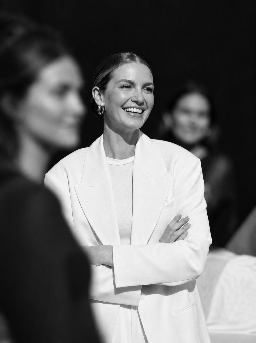 A woman in a white suit, smiling